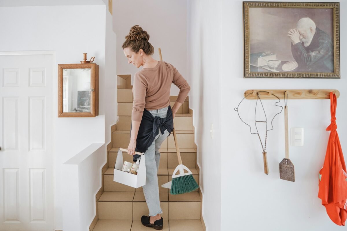 Persona subiendo una escalera con útiles de limpieza