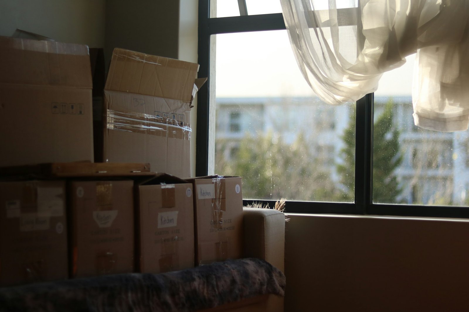 Cajas de cartón junto a una ventana en una vivienda