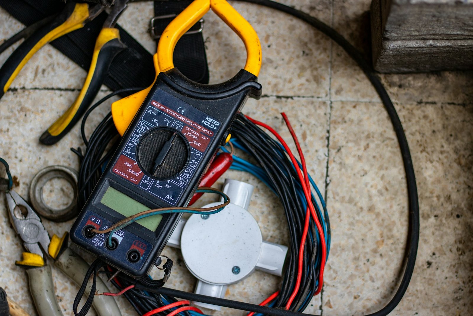 Pinza amperimétrica y cables sobre el suelo