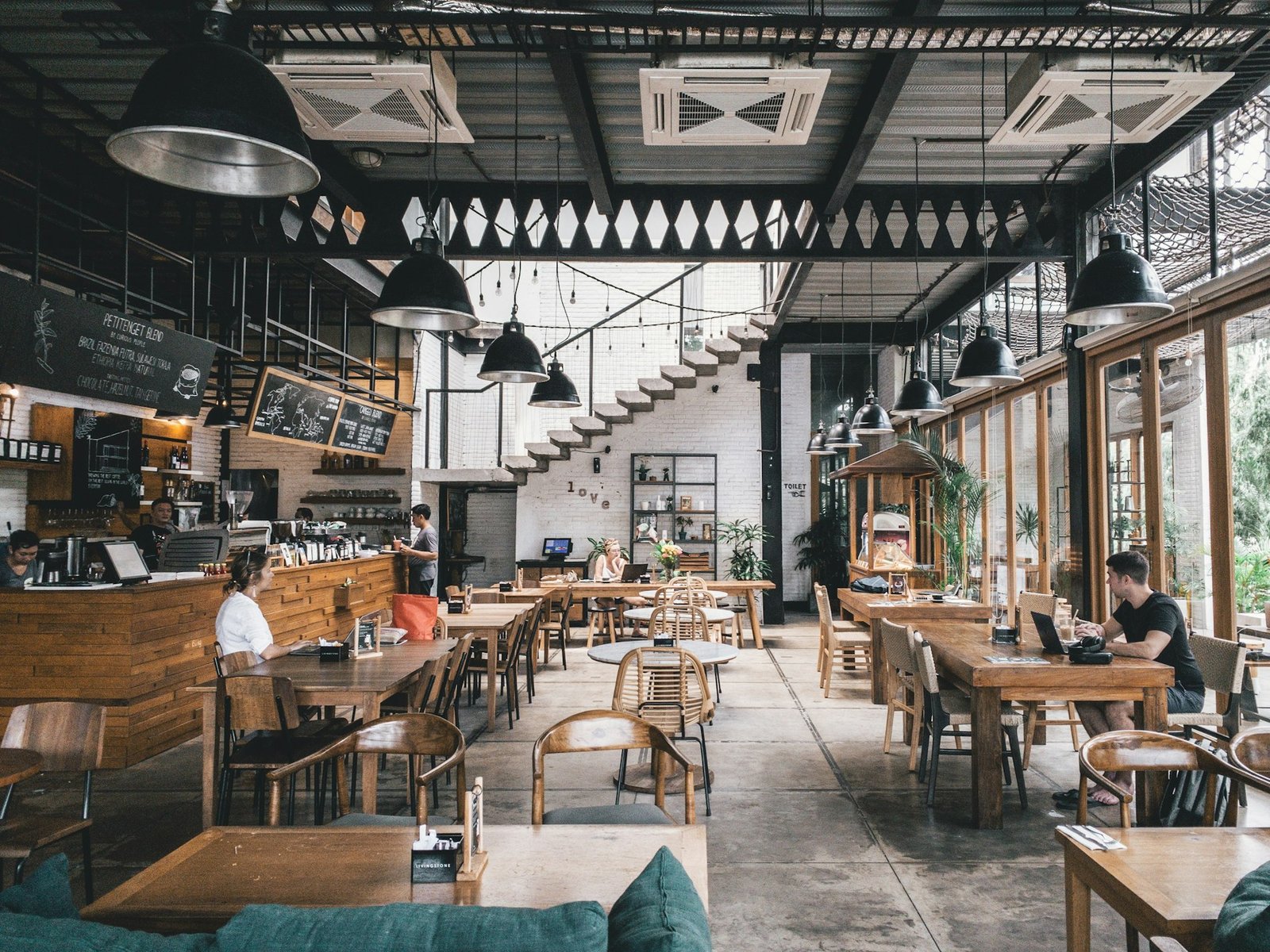 Sala de un restaurante con mesas de madera preparadas para el servicio