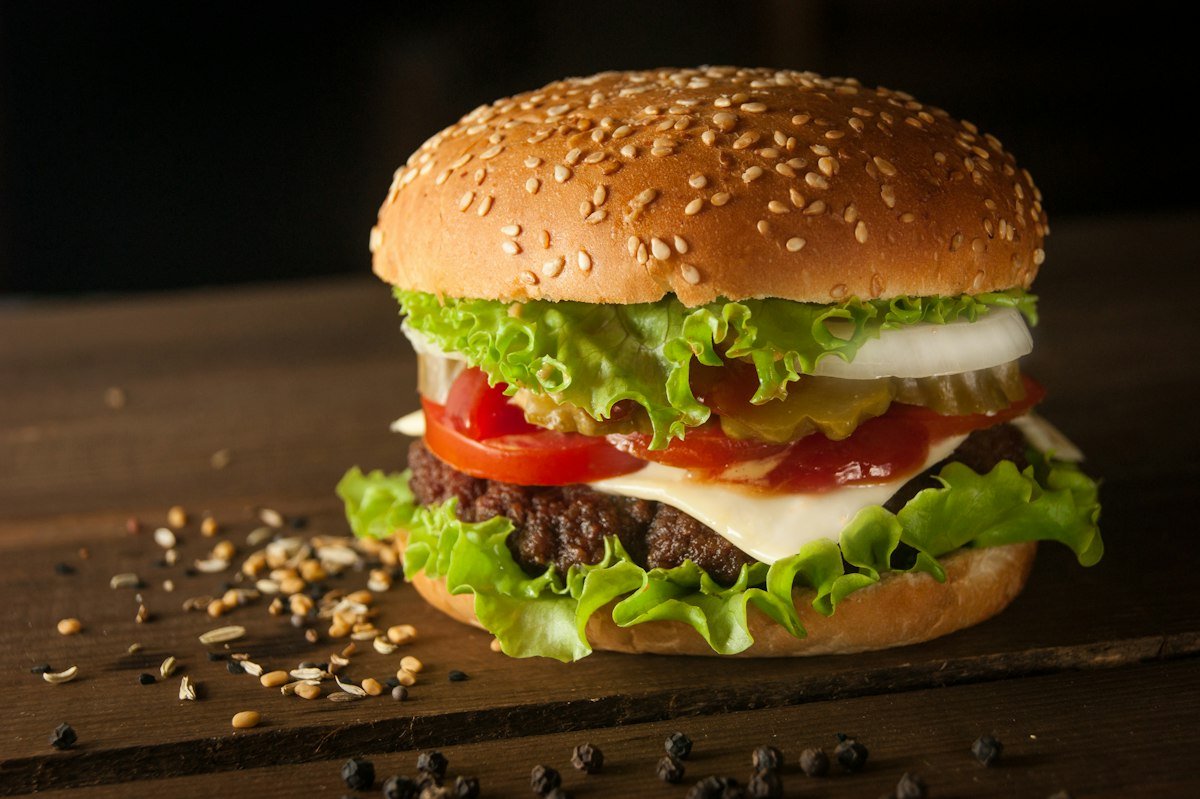 Hamburguesa con queso, lechuga y tomate sobre una tabla
