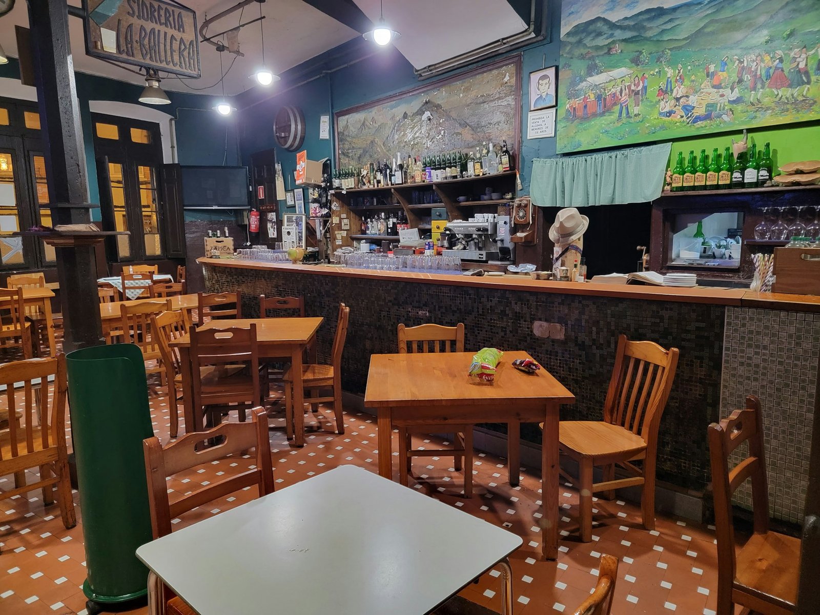 Comedor de una sidrería con mesas y sillas de madera