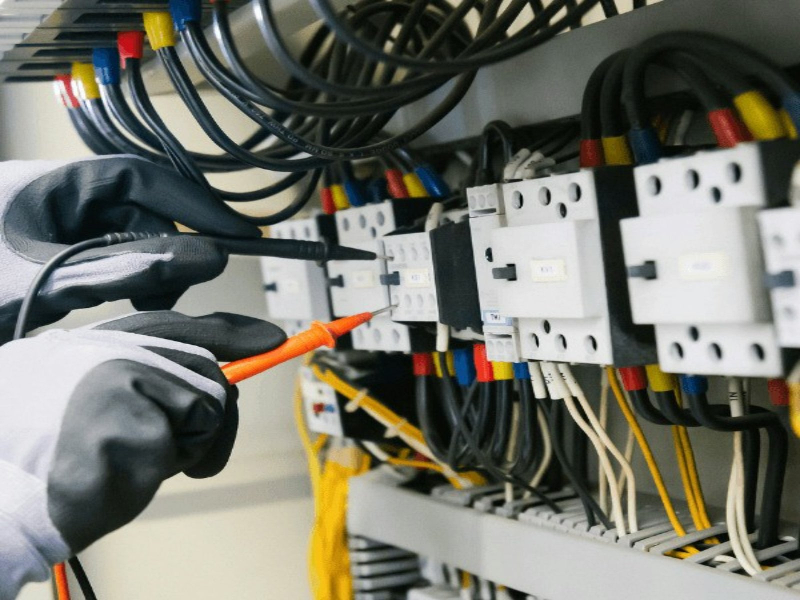 Electricista comprobando un cuadro eléctrico con un multímetro